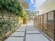 A serene stone walkway lined with lush greenery and modern wood fencing leading to a residence at 641 Lake Catherine Dr, Maitland, FL 32751