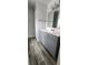Bathroom with wood look flooring, light blue vanity, and neutral walls at 658 Olympic Dr, Ocoee, FL 34761