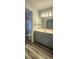 Bathroom featuring a modern vanity with wood-look floors and a stylish, tiled shower at 658 Olympic Dr, Ocoee, FL 34761
