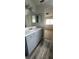 Bathroom with wood look flooring, light blue vanity, neutral walls, and view of bedroom at 658 Olympic Dr, Ocoee, FL 34761