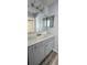 Bathroom with new vanity, double mirrored cabinet, lighting and modern wood-look floors at 658 Olympic Dr, Ocoee, FL 34761