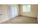Bedroom with neutral carpet, large closet, window, and neutral paint at 658 Olympic Dr, Ocoee, FL 34761