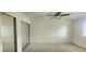 Main bedroom featuring a closet with mirror doors, plush carpeting, and a ceiling fan at 658 Olympic Dr, Ocoee, FL 34761