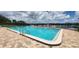 Community pool featuring a lake view, lounge seating, and a black metal fence at 658 Olympic Dr, Ocoee, FL 34761