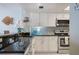 Cozy kitchen featuring granite counters, stainless steel appliances, and blue tile backsplash at 6727 Turtlemound Rd # 417, New Smyrna Beach, FL 32169