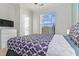 Bright bedroom with a large window, patterned bedding, and a ceiling fan at 8000 Tuscany Way # 4405, Davenport, FL 33896