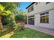Backyard featuring lush green landscaping and a brick paved patio and grass area at 8149 Via Vittoria Way, Orlando, FL 32819