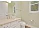 A clean bathroom featuring a vanity with marble top, white toilet, and window with shutters at 8149 Via Vittoria Way, Orlando, FL 32819