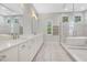 Bright bathroom features double vanities with a freestanding tub and glass enclosed shower at 8149 Via Vittoria Way, Orlando, FL 32819