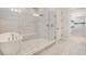 This bathroom showcases a glass shower, freestanding tub, and natural light at 8149 Via Vittoria Way, Orlando, FL 32819