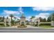 Community entrance featuring manicured landscaping and gate house under a blue sky at 8149 Via Vittoria Way, Orlando, FL 32819