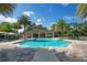 Community pool featuring lounge chairs and umbrellas surrounded by palm trees at 8149 Via Vittoria Way, Orlando, FL 32819