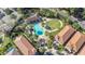 Aerial view of a community pool and clubhouse with palm trees and green spaces at 8149 Via Vittoria Way, Orlando, FL 32819