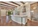 An open-concept kitchen with wooden beams, stainless steel appliances, a large island and hardwood floors at 8149 Via Vittoria Way, Orlando, FL 32819