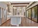 An open-concept kitchen with wooden beams, stainless steel appliances, a large island and hardwood floors at 8149 Via Vittoria Way, Orlando, FL 32819