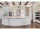 Open kitchen design featuring white cabinetry, a large island, stainless appliances, and wood beam accents at 8149 Via Vittoria Way, Orlando, FL 32819
