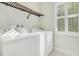 Functional laundry room features a washer, dryer, and built in shelving at 8149 Via Vittoria Way, Orlando, FL 32819