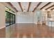 Open-concept living space with hardwood floors, exposed beams, and access to the kitchen and backyard at 8149 Via Vittoria Way, Orlando, FL 32819