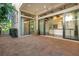 An outdoor patio with brick flooring, large glass doors, and an outdoor wooden barrel table at 8149 Via Vittoria Way, Orlando, FL 32819