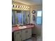 Well-lit bathroom featuring a single sink vanity, a large mirror, and a window at 103 Dreama Dr, Davenport, FL 33897
