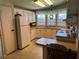 Bright kitchen featuring a refrigerator, white cabinets, and an eat-in counter at 103 Dreama Dr, Davenport, FL 33897