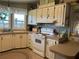 Well-lit kitchen featuring tan countertops, wooden cabinets, and a white stove at 103 Dreama Dr, Davenport, FL 33897
