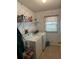 Functional laundry room with washer, dryer, storage shelves, and floral wallpaper at 103 Dreama Dr, Davenport, FL 33897