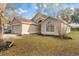 Side view of a single Gathering home with lawn covered in leaves at 113 Glasgow Ct, Davenport, FL 33897