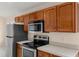 A close up of the appliances in the kitchen featuring wooden cabinetry at 113 Glasgow Ct, Davenport, FL 33897