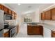 Kitchen with wood cabinets, tile flooring, and stainless steel appliances at 113 Glasgow Ct, Davenport, FL 33897