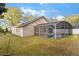 Exterior view of home with a screened pool and green lawn at 113 Glasgow Ct, Davenport, FL 33897