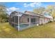 Exterior view of a home with a screened pool and green lawn at 113 Glasgow Ct, Davenport, FL 33897