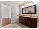 Bathroom boasts double sinks with a wooden cabinet, a large mirror, and tile flooring at 1132 Hardy Ave Ave, Orlando, FL 32803