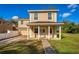 Two-story home with a welcoming covered front porch, tan siding, and well-maintained landscaping at 1132 Hardy Ave Ave, Orlando, FL 32803