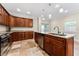 Kitchen features granite countertops, an island with a sink, tile flooring, and wood cabinetry at 1132 Hardy Ave Ave, Orlando, FL 32803