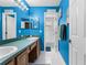 Vibrant blue bathroom with a double vanity and a separate toilet and shower area at 13506 Crystal River Dr, Orlando, FL 32828