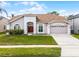 Well-maintained single-story home with a manicured lawn and a two-car garage at 13506 Crystal River Dr, Orlando, FL 32828