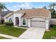 Charming single-story home with a manicured lawn, two-car garage, and neutral color scheme at 13506 Crystal River Dr, Orlando, FL 32828