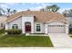 Charming single-Gathering home with a well-manicured lawn, arched windows, and a two-car garage, showcasing curb appeal at 13506 Crystal River Dr, Orlando, FL 32828