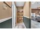 Hallway with a display shelf, neutral walls, and decorative trim leading to the living room with cozy furnishings at 13506 Crystal River Dr, Orlando, FL 32828