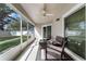 Covered patio with comfortable seating, ceiling fan, and a serene backyard view at 13506 Crystal River Dr, Orlando, FL 32828