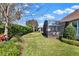 Lush backyard featuring a manicured lawn, vibrant landscaping, and a screened-in outdoor patio at 1382 Hayton Ave, Deland, FL 32724