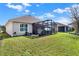 Spacious backyard featuring a well-manicured lawn, lush greenery, and a screened-in patio area at 1382 Hayton Ave, Deland, FL 32724