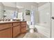 Bathroom with wood cabinets, granite counters, a toilet, and a tub-shower combo at 1382 Hayton Ave, Deland, FL 32724