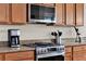 Gourmet kitchen features stainless steel range, granite countertops, and custom wood cabinetry at 1382 Hayton Ave, Deland, FL 32724