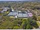 Aerial view of the community tennis courts and surrounding wooded landscape in a desirable neighborhood at 1382 Hayton Ave, Deland, FL 32724