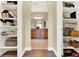 View of walk-in closet leading to bathroom with white shelves for ample storage at 1382 Hayton Ave, Deland, FL 32724