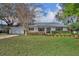 Charming one-story home features a well-manicured lawn, mature landscaping, and a cozy brick-accented entryway at 1409 Overlake Ave, Orlando, FL 32806
