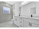 Bright bathroom featuring a double vanity with white cabinets, granite countertops, and modern fixtures at 142 Guava Pass, Ocklawaha, FL 32179