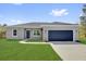 Charming single-story home featuring a blue garage door, fresh lawn, and a modern gray exterior at 142 Guava Pass, Ocklawaha, FL 32179